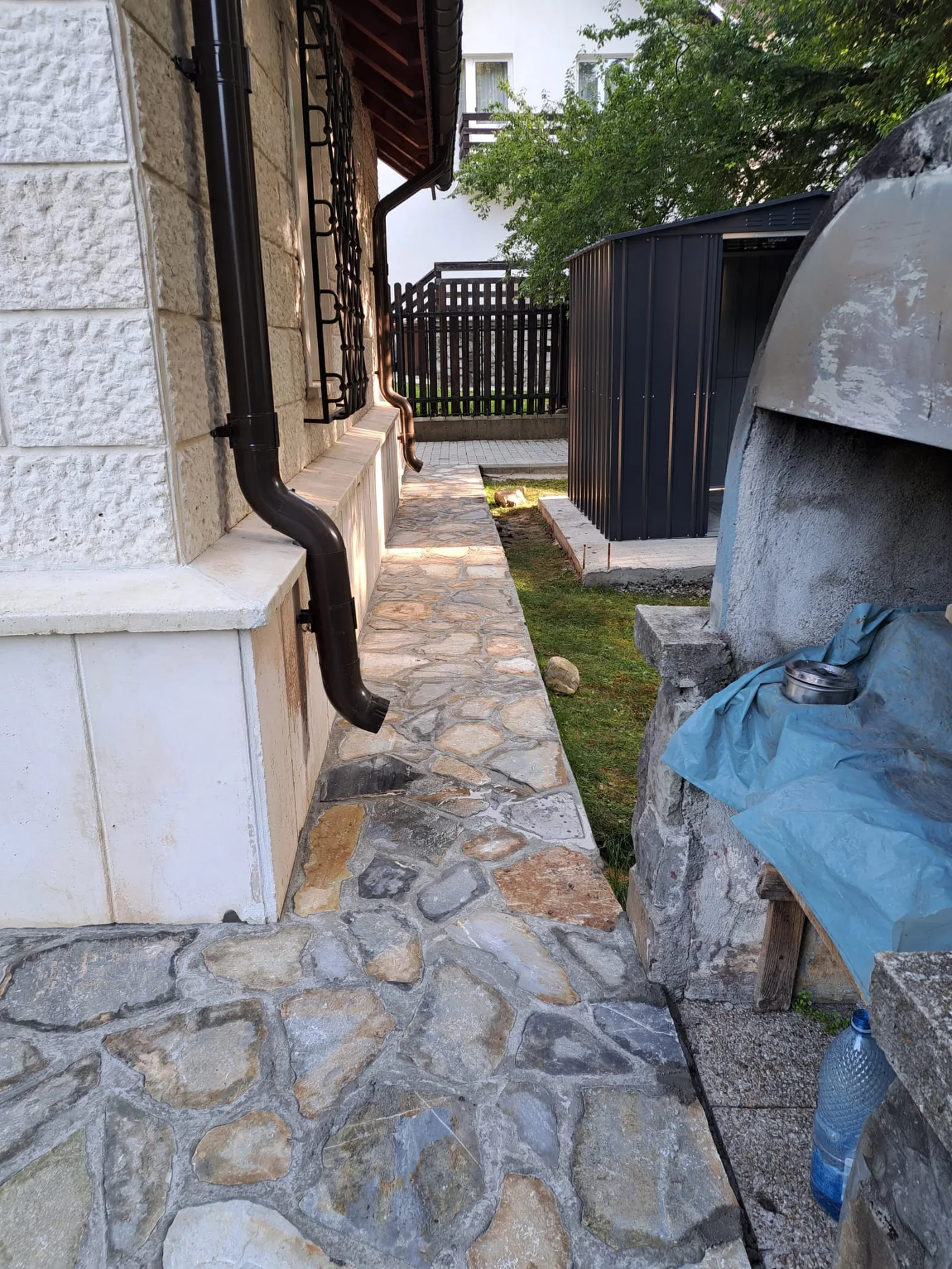 Alee îngustă din piatră naturală realizată pe lângă casă.