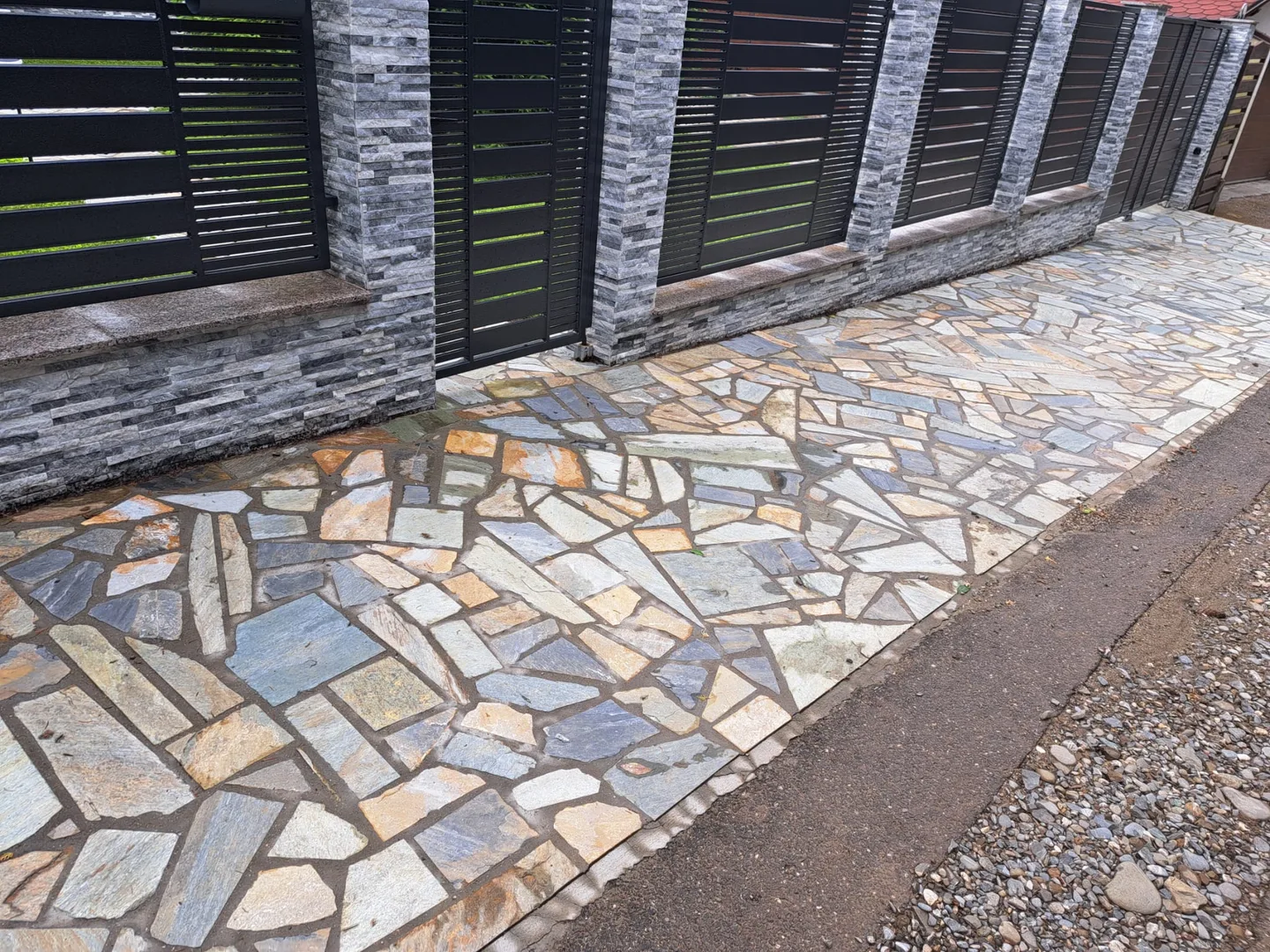 Trotuar exterior realizat cu piatră naturală.